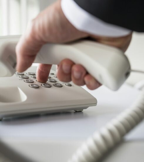 Businessman dialing a telephone number